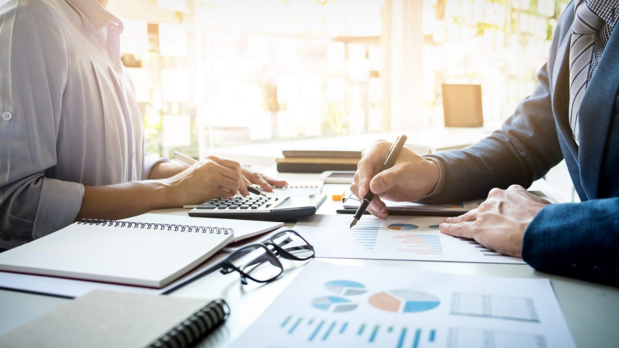 Photo of man and woman looking at financial charts illustrates blog "What Is Cost Segregation in Real Estate?"