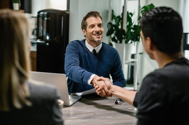 Photo of two men shaking hands illustrates blog "Commercial Real Estate: The Benefits of Seller Financing"