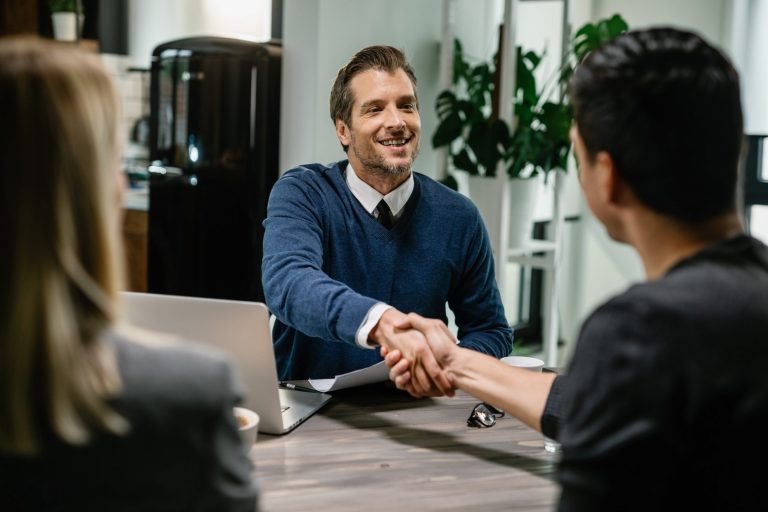 Photo of two men shaking hands illustrates blog "Commercial Real Estate: The Benefits of Seller Financing"