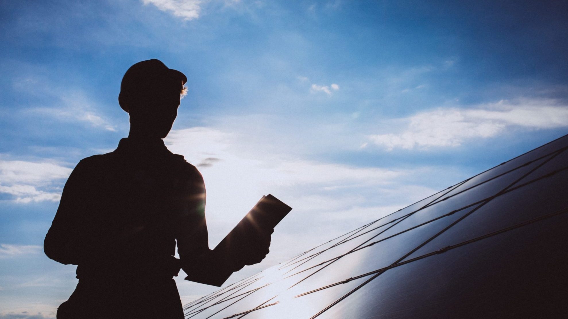 Photo of worker by solar panel illustrates blog: "What Is a Sustainable Warehouse?"