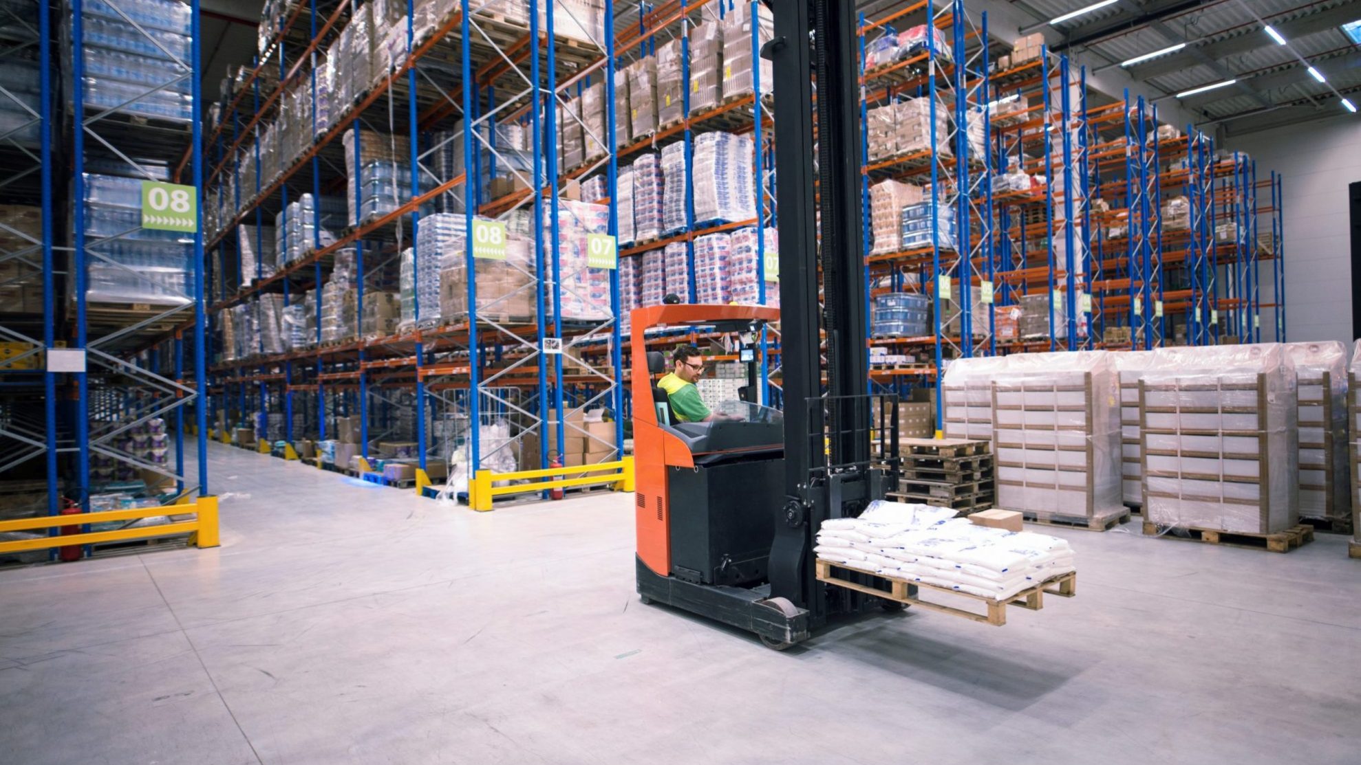Photo of man operating forklift in warehouse illustrates blog "Public Warehouse, Contract Warehouse, Private Warehouse: What Is the Difference?"