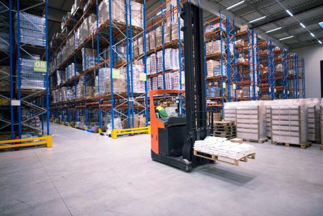 Photo of man operating forklift in warehouse illustrates blog "Public Warehouse, Contract Warehouse, Private Warehouse: What Is the Difference?"