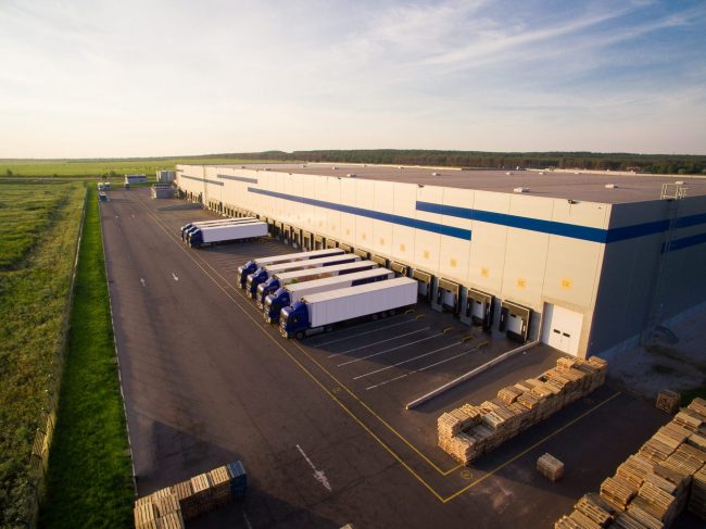 Distribution center with trucks parked outside illustrates blog "Reminder: L.A.’s “Mansion Tax” Kicks In April 1, 2023"